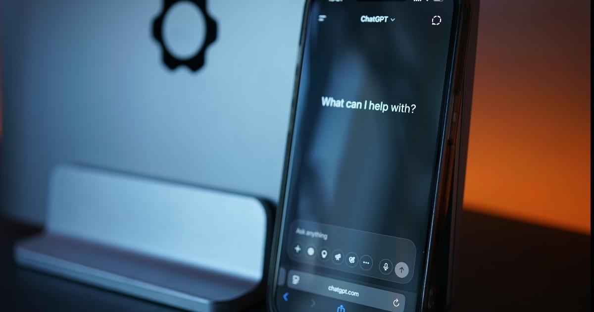 En smartphone visar ChatGPT-frågan "What can I help with?" med en modern design, perfekt för webbutveckling och AI-appar